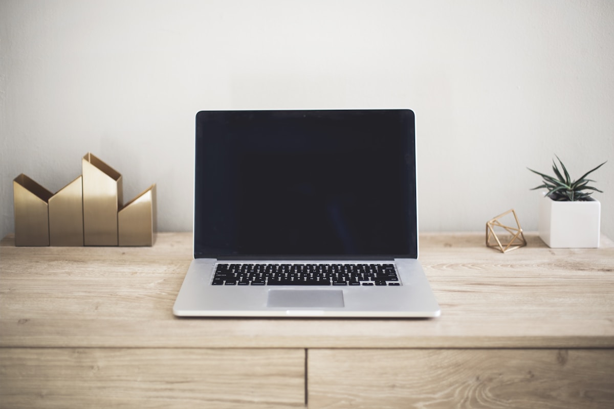 Laptop encendido sobre un escritorio de madera cálido, listo para la maratón estés donde estés